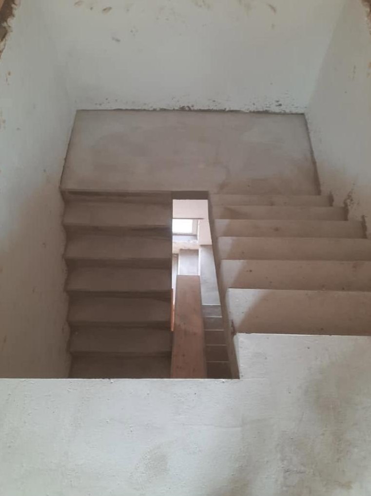 Bovenaanzicht van een betontrap met tussenbordes in een ruwbouw