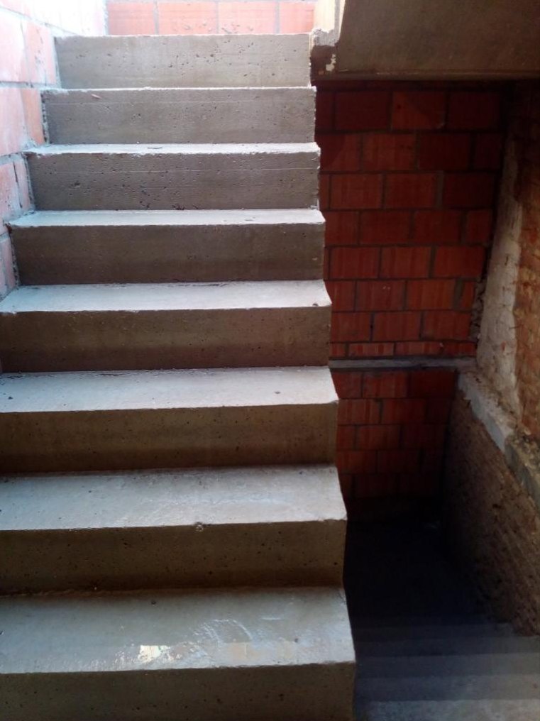 Pas ontkiste rechte betontrap naast een bakstenen muur